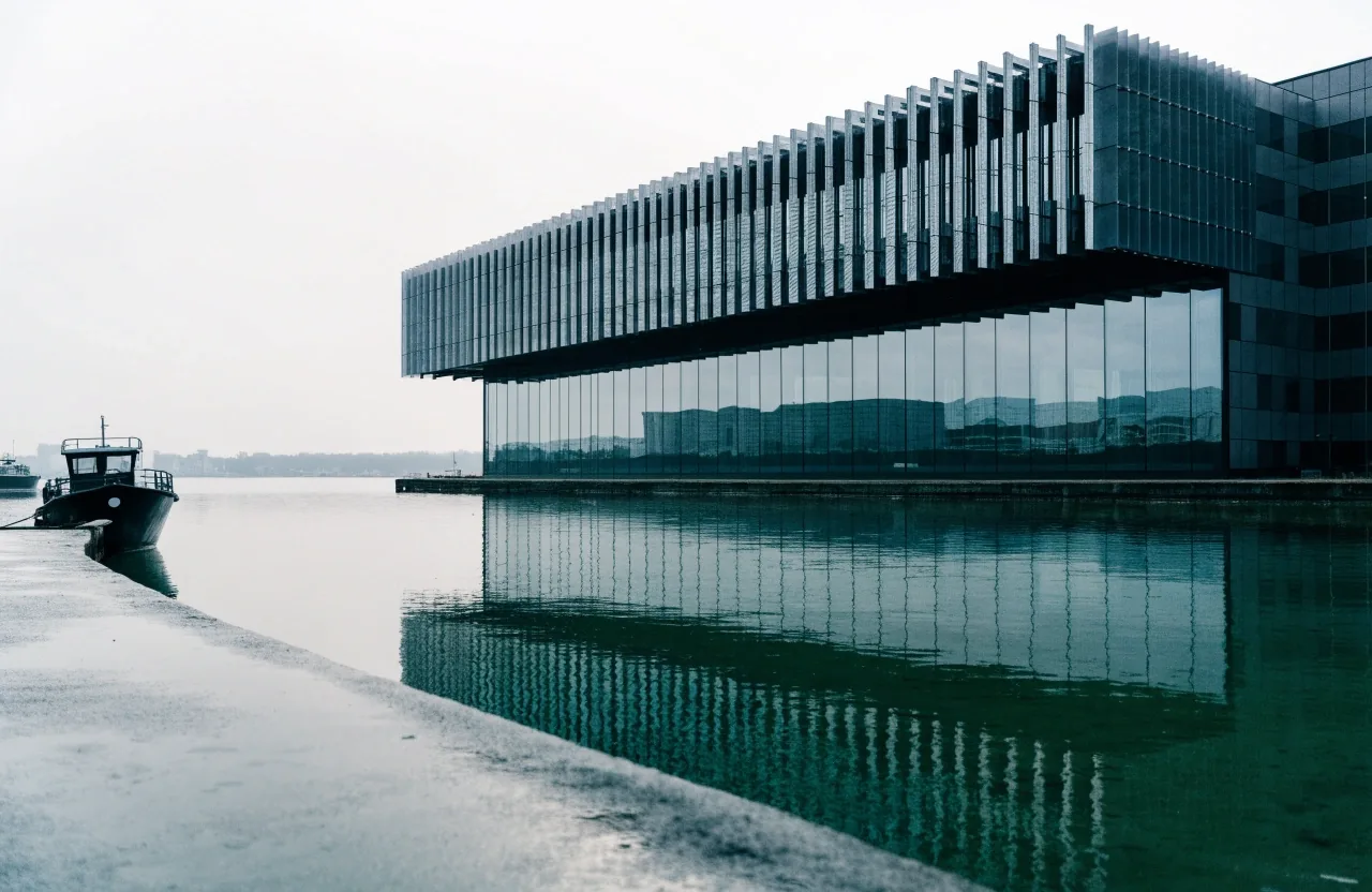 Forschungsgebäude am Hafen im Norden bei bedecktem Morgenlicht, davor ein Arbeitsboot
